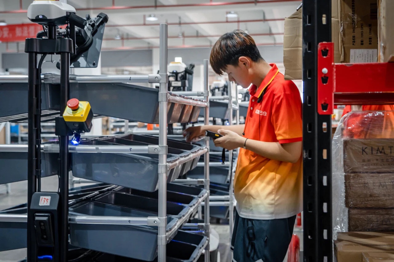 Warehouse worker scanning a pick at a Syrius PA-AMR shelf cart